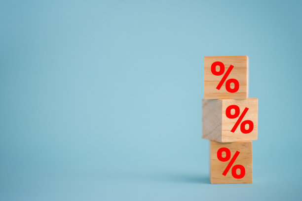 利率金融和抵押利率概念在木制立方体与蓝色背景上的图标百分比符号。图片下载