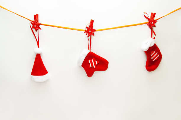 时尚的构图用圣诞衣夹挂在绳子上，节日的装饰品在白色的背景上。新年的概念图片下载