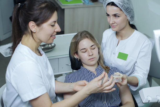 牙科医生和助手向病人解释，在有机颌骨展览的例子中，颌骨的问题隐藏在哪里图片下载