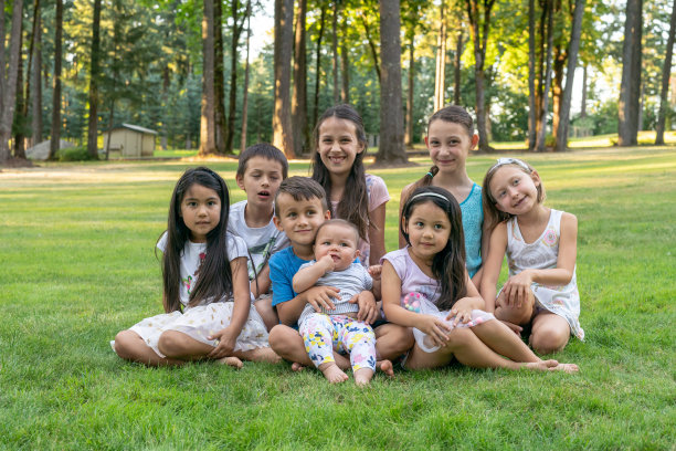 多民族儿童坐在草地上的肖像图片下载