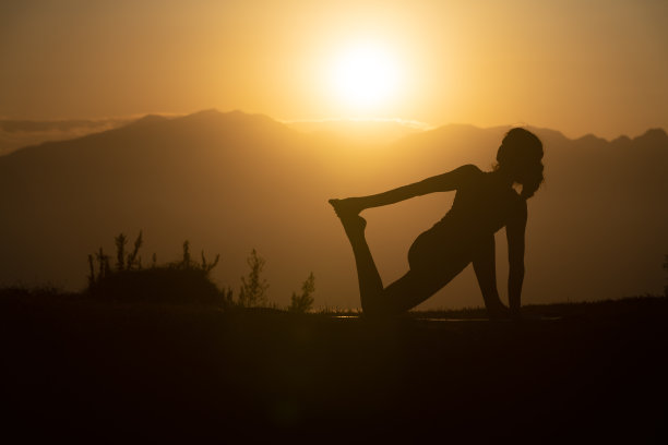 日落时练习瑜伽的成年女性的轮廓照片图片下载