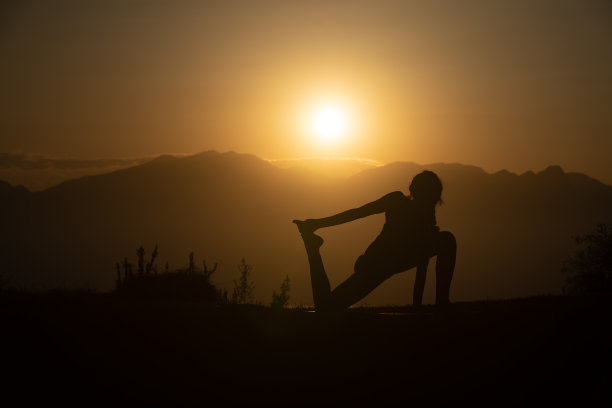 日落时练习瑜伽的成年女性的轮廓照片图片下载