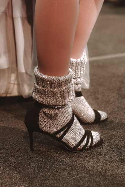 女性脚上穿着针织的银色袜子和黑色高跟鞋。图片下载