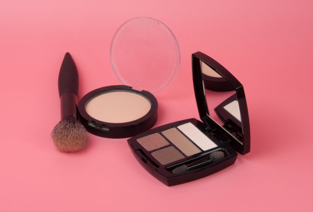 眼影粉与刷哑光调色板的粉色背景上的妆图片下载