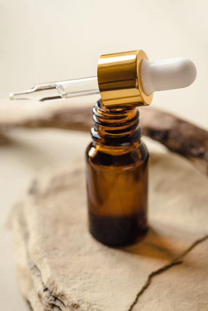 一个棕色的化妆品瓶子在天然的米色背景上。图片下载