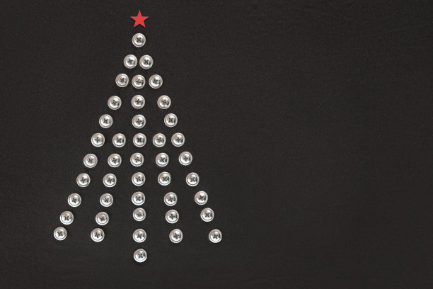 黑色背景上的一棵钉满螺丝钉的圣诞树。平的。副本的空间。由建筑工具制成的不寻常圣诞树。创意工业贺卡。构建、修复的概念。车间。前视图。图片下载