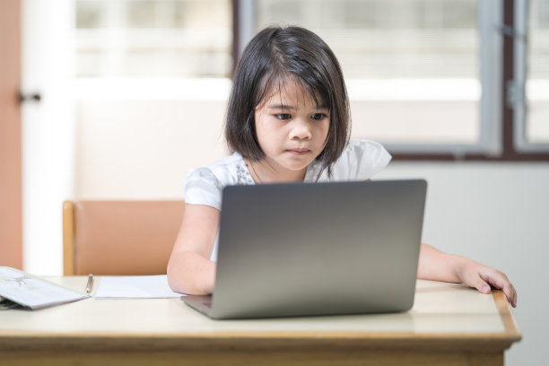 亚洲女学生在家里通过笔记本电脑上网学习时在笔记本上写作。教育概念专题图片图片下载