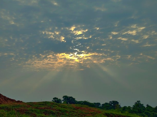 这是一张美丽的太阳光线从云层中央散发出来的照片。图片下载