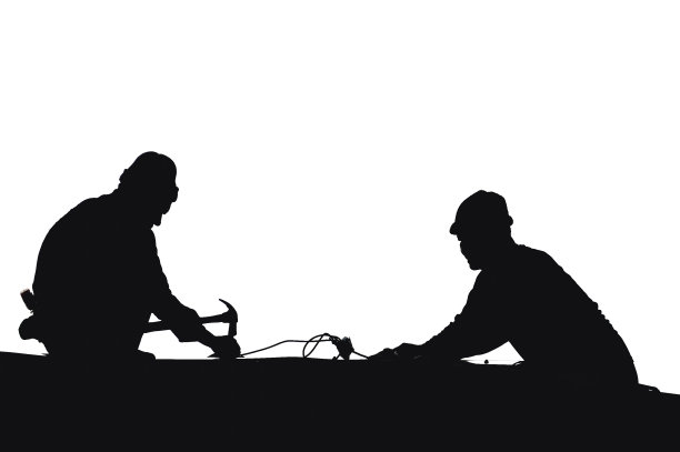 背景为天空的屋顶上的工人剪影，安装新的屋顶，安装沥青瓦，施工概念图片下载