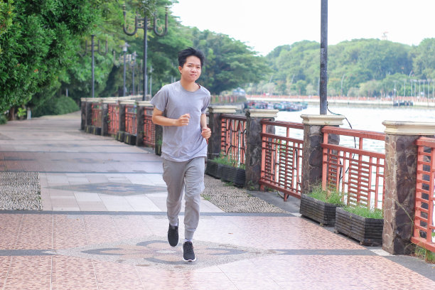 在阳光明媚的日子里，年轻人在公园里锻炼身体图片下载