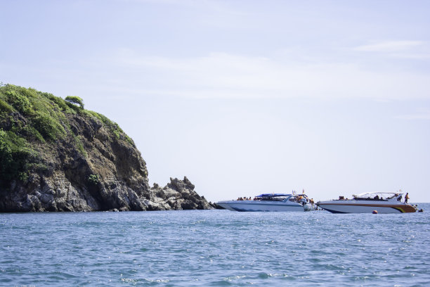 在海边的小岛上，一艘小船停下来带游客来浮潜。沙美岛，泰国湾，罗勇省，为泰国旅游业做宣传。图片下载