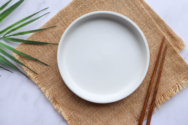 用木筷子在麻布上的白色空盘子图片下载