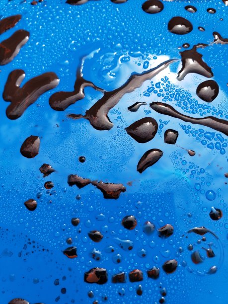 蓝色表面上的棕色颜料滴，特写镜头。宏观照片图片下载