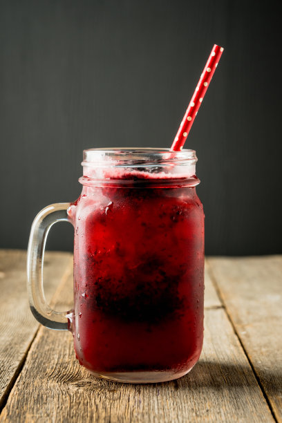 黑莓鸡尾酒与碎冰在玻璃罐上的乡村木制背景。有选择性的重点。景深浅。图片下载