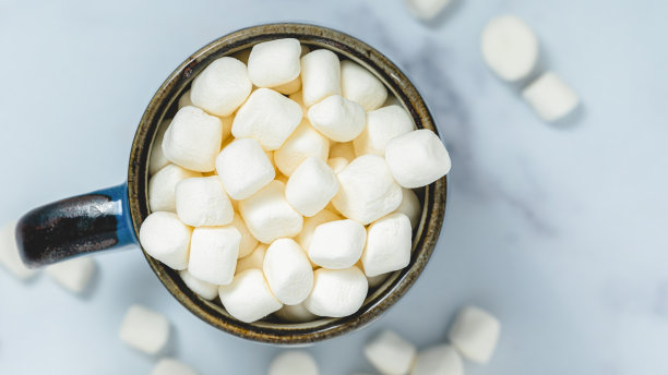 棉花糖在咖啡杯极端近距离从上面浅蓝色大理石背景与复制空间图片下载