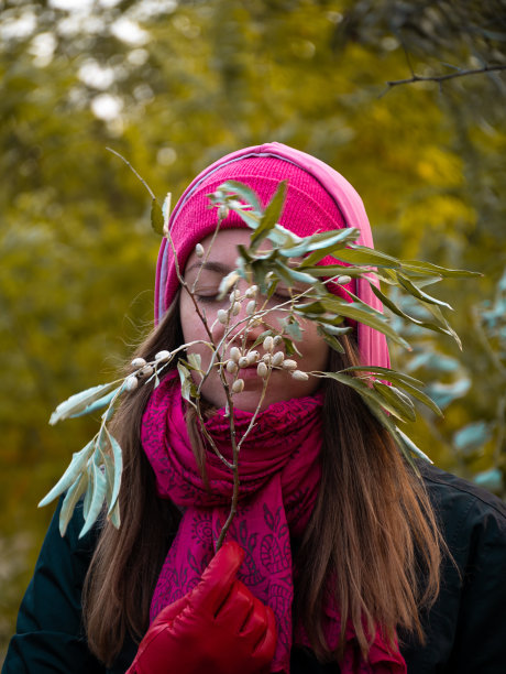 漂亮的微笑快乐的女人在粉红色的帽子野橄榄行走在秋天的森林自然的背景。现实生活的生活方式图片下载