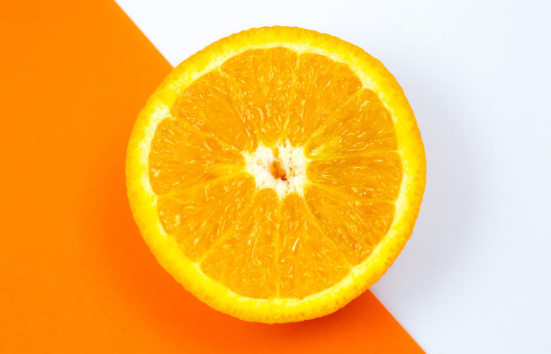 橙色水果在白色和橙色背景上的特写照片。柑橘切成两半，内部，宏观视图。极简主义，原创和创意的形象。美丽的自然墙纸。图片下载