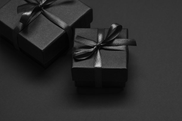 黑色背景上系着黑色丝带的黑色礼品盒。图片下载