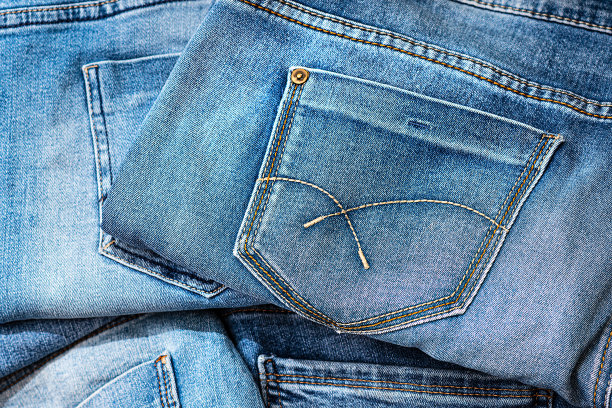 蓝色牛仔裤的背景。棉布牛仔布蓝色牛仔裤。带有磨损痕迹的经典牛仔裤图片下载