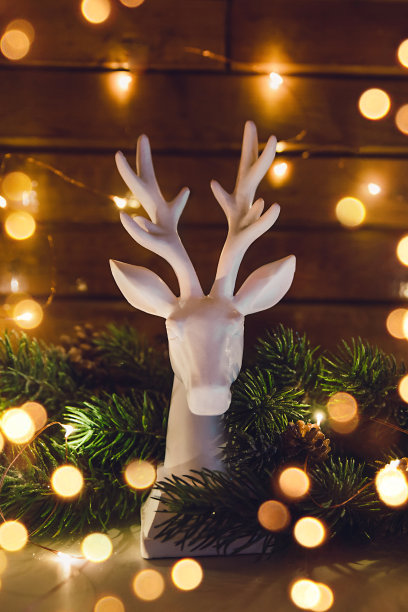 圣诞树上的驯鹿雕像，圣诞节闪闪发光的花环图片下载