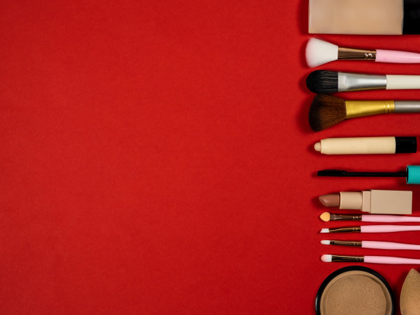 一套装饰性的化妆品。口红，粉底和化妆刷，粉底，化妆刷，遮瑕膏。化妆品。红色的背景。图片下载