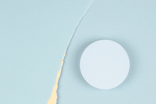 俯视图几何圆形讲台为产品展示，粉彩黄色和浅蓝色撕裂纸背景图片下载