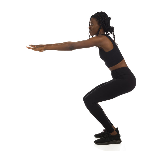 一个穿着黑色运动服的女人正在蹲着。全长，侧视图。图片下载
