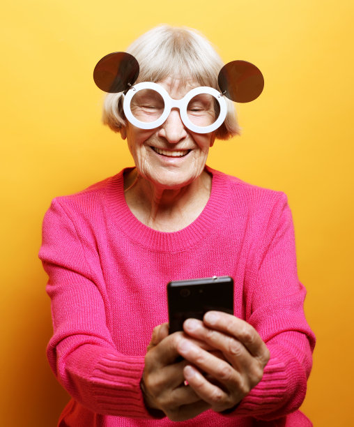 生活方式和人的观念:老祖母在电话里和她的孙子聊天，微笑着和他们打招呼图片下载