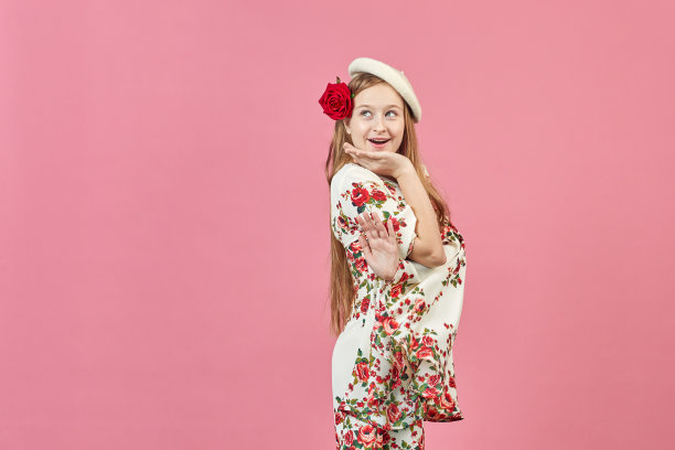 一个美丽优雅的女孩的时尚肖像，穿着漂亮的裙子，粉红色的背景上有花。年轻的金发女人，穿着漂亮的春装。时尚春夏概念。图片下载