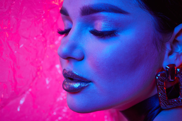 夜店里，模特在霓虹灯下摆姿势。美丽性感的女孩的肖像与时尚的化妆。图片下载