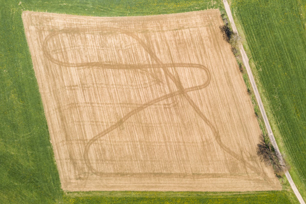 德国巴伐利亚森林，绿地和土路环绕着田野和履带，无人机拍摄的图像图片下载