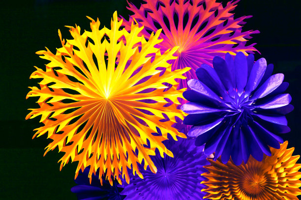 彩色纸花在黑暗的背景图片下载