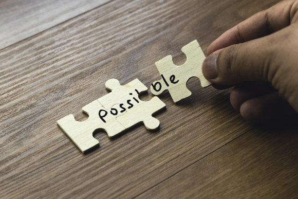 一个手握的字谜，字词可能分散在两个部分。解决问题和克服挑战的概念。图片下载