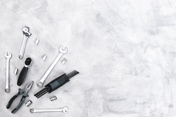 各式各样的金属工具，钳子，扳手，螺丝刀，钻头在水泥灰色地板上俯视图。建筑背景与复制空间。图片下载