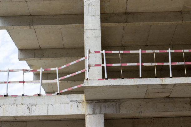 正在建造中的现代建筑的立面碎片。一个多层住宅建筑的特写。房子的墙壁在工作和建筑过程中。图片下载