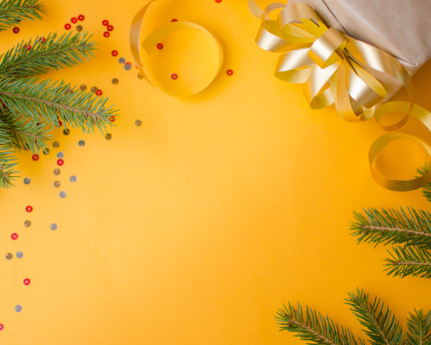 圣诞贺卡与礼物和云杉树枝。带有复制空间的黄色背景图片下载