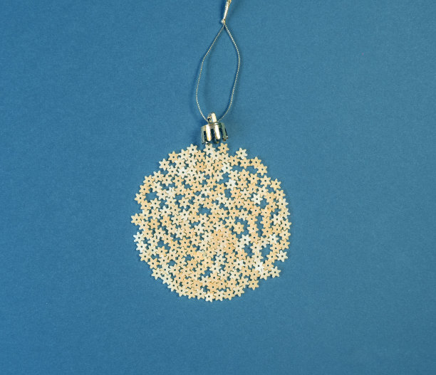 圣诞树上装饰成球状的意大利面，背景为蓝色的纸，俯视图。概念上的照片。图片下载