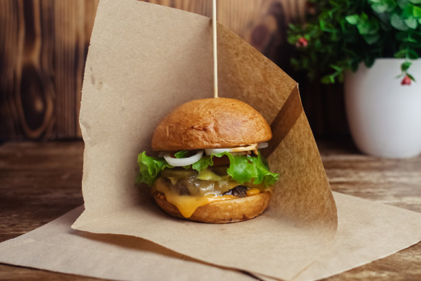 一个标准汉堡的特写镜头。餐馆或咖啡馆里的成人快餐。微距照片的汉堡原料与肉，奶酪和香草。为全家准备的环保汉堡图片下载