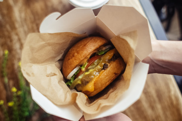 一个标准汉堡的特写镜头。餐馆或咖啡馆里的成人快餐。微距照片的汉堡原料与肉，奶酪和香草。为全家准备的环保汉堡图片下载