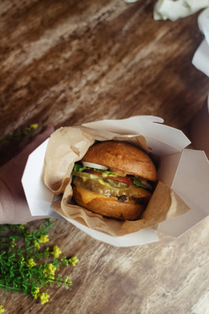 一个标准汉堡的特写镜头。餐馆或咖啡馆里的成人快餐。微距照片的汉堡原料与肉，奶酪和香草。为全家准备的环保汉堡图片下载