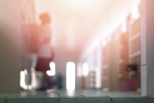 教育背景的概念。教室前面的走廊里，一群年轻的小学生正在把东西装进储物柜里，准备学期结束时离开学校。图片下载