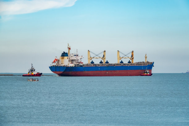 一艘带着向导离开港口的货船图片下载