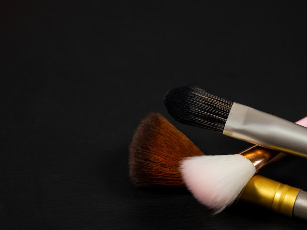 粉和化妆刷。一套装饰性的化妆品。化妆品。黑色背景。图片下载