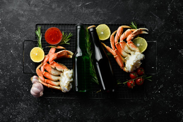 黑色背景上的啤酒和蟹爪。乡村风格。海鲜美食。图片下载