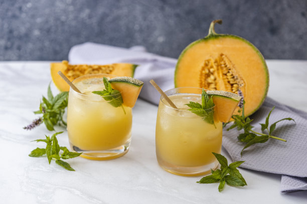 甜瓜汁，柠檬汁，加冰和罗勒叶装饰的甜瓜片图片下载
