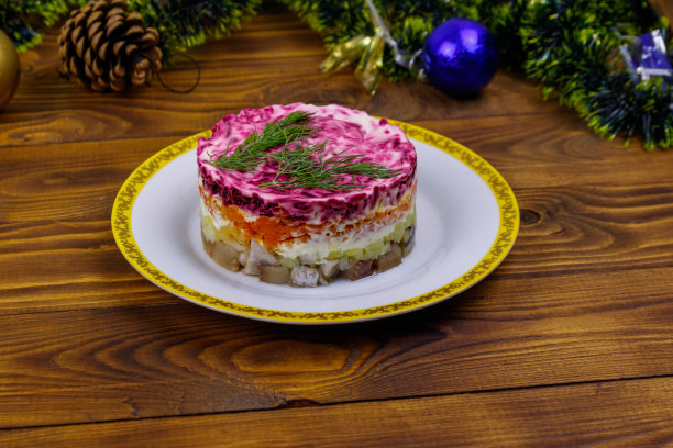 传统的俄罗斯沙拉“皮大衣下的鲱鱼”(shuba)和木桌上的圣诞装饰图片下载