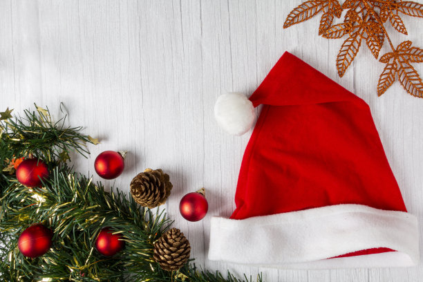木桌上有圣诞装饰的圣诞老人帽子。图片下载