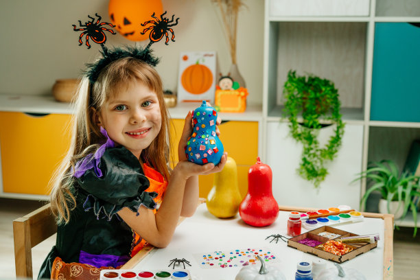孩子们用亮闪闪的贴纸装饰彩色的南瓜图片下载