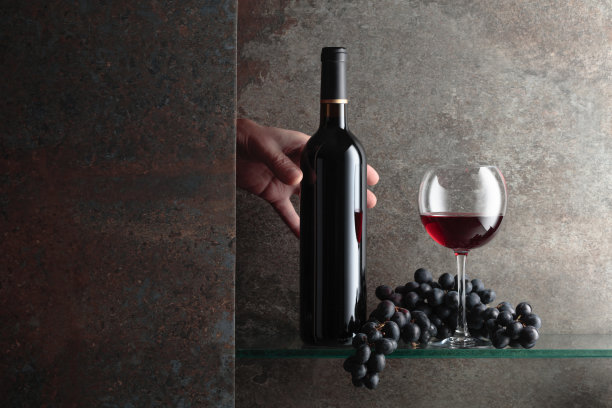 手伸向一瓶红酒。图片下载