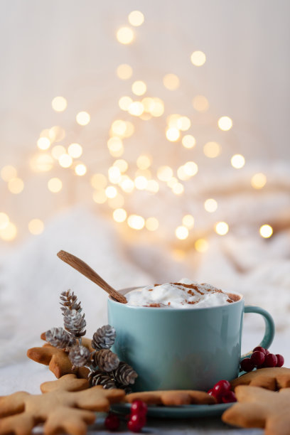 冬季热饮:蓝色马克杯巧克力鲜奶油。圣诞节的时间。舒适的家庭氛围，白色的背景。自制的姜饼饼干，圆锥形，蜡烛，灯作为装饰。节日喜庆的气氛图片下载